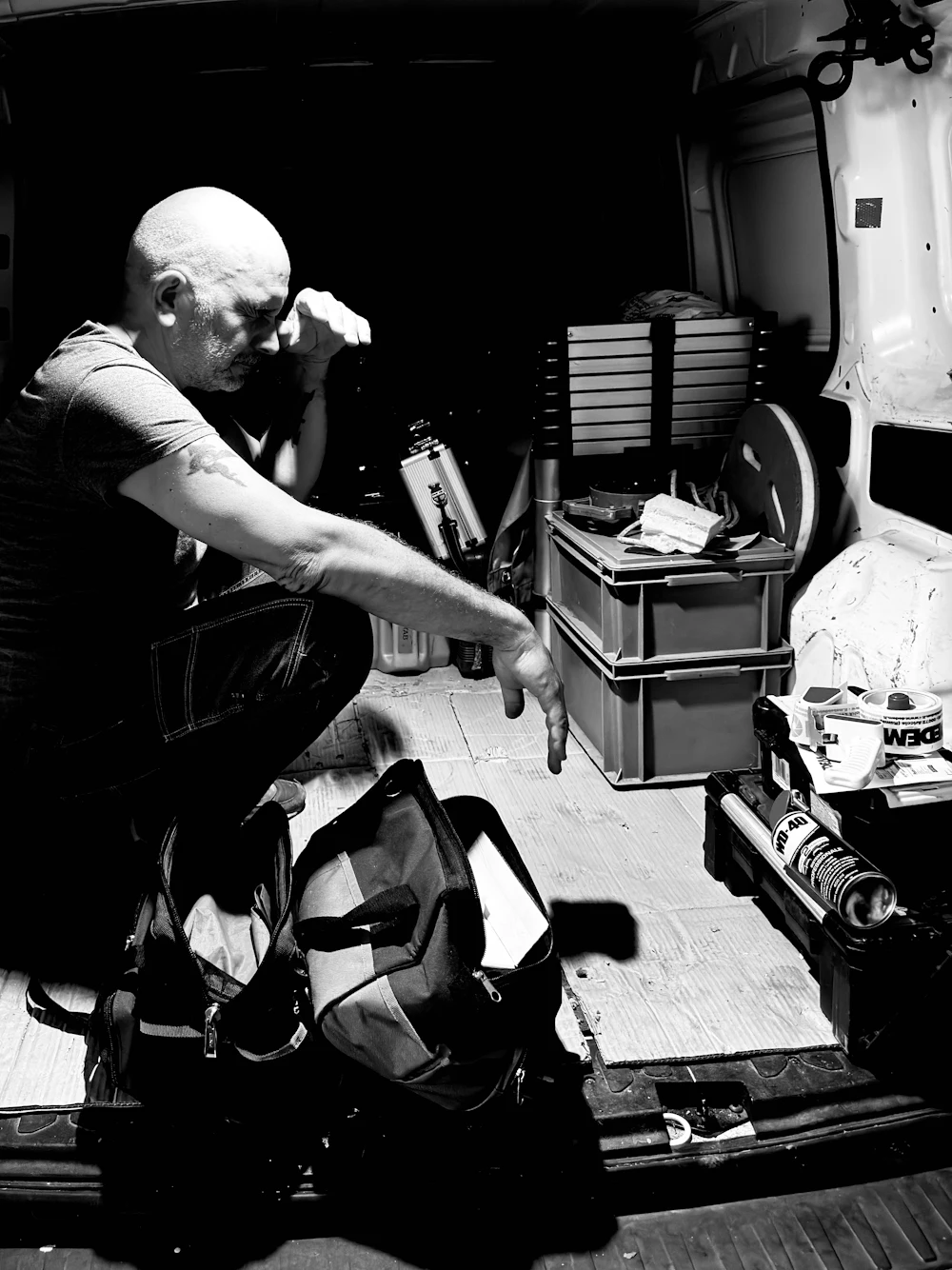 Mick Halloran crouching in the back of the van sorting tools